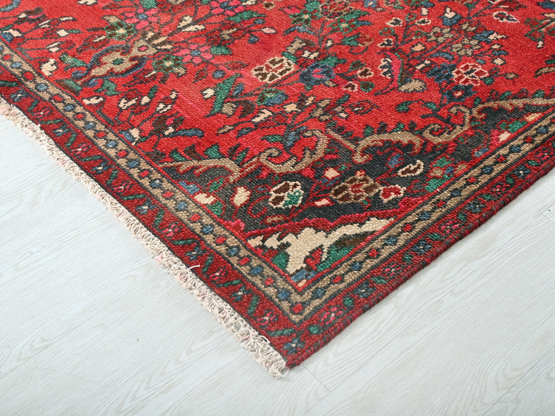 a red oriental rug on a white wooden floor