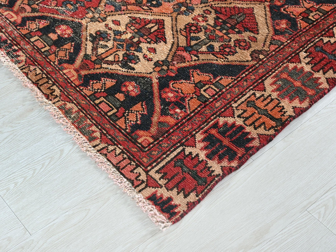 a red and black oriental rug on a white floor