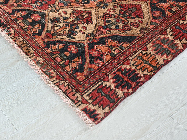 a red and black oriental rug on a white floor