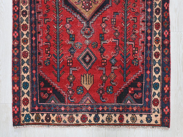 a red rug with a blue border on a white floor