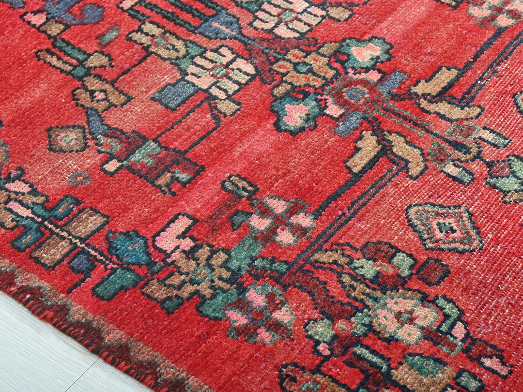 a red rug with a floral design on it