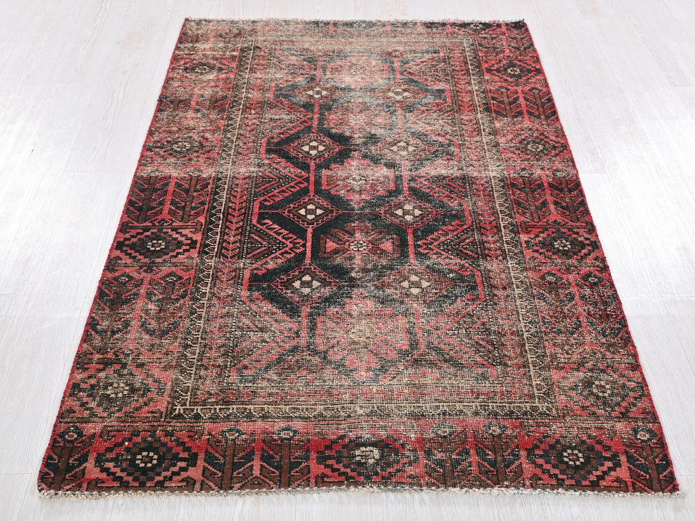 a red and black rug on a white floor