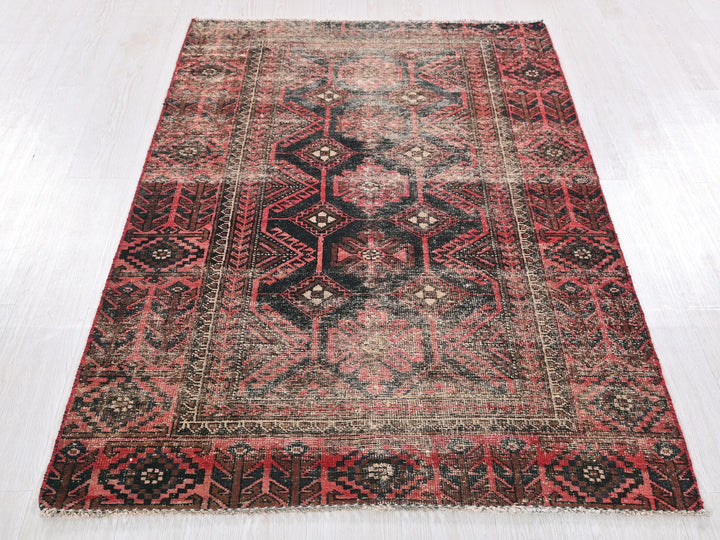 a red and black rug on a white floor