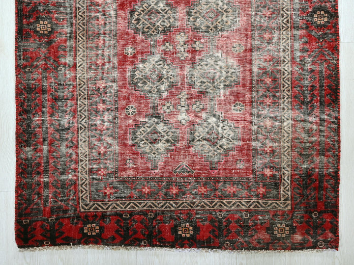 a red and black oriental rug on a white background