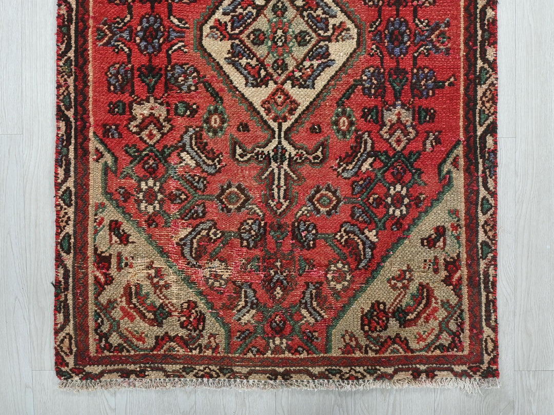 a red rug with a design on the middle of it