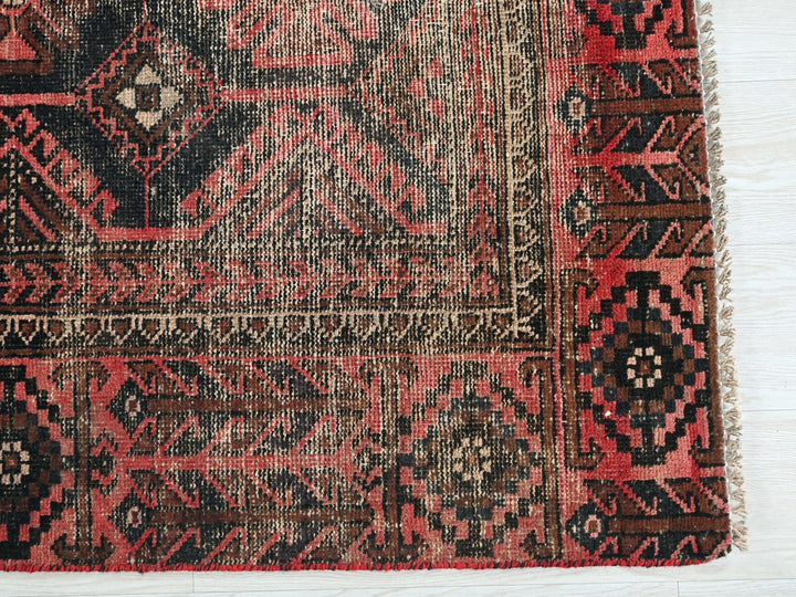 a red and black rug on a white floor