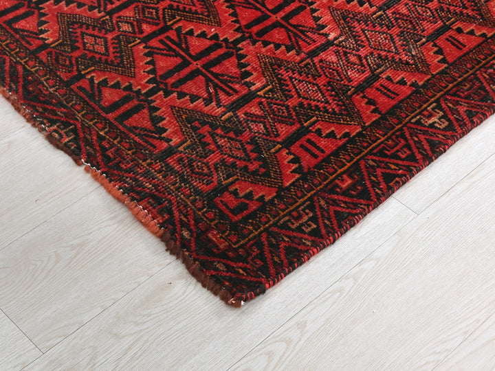a red and black rug on a white floor