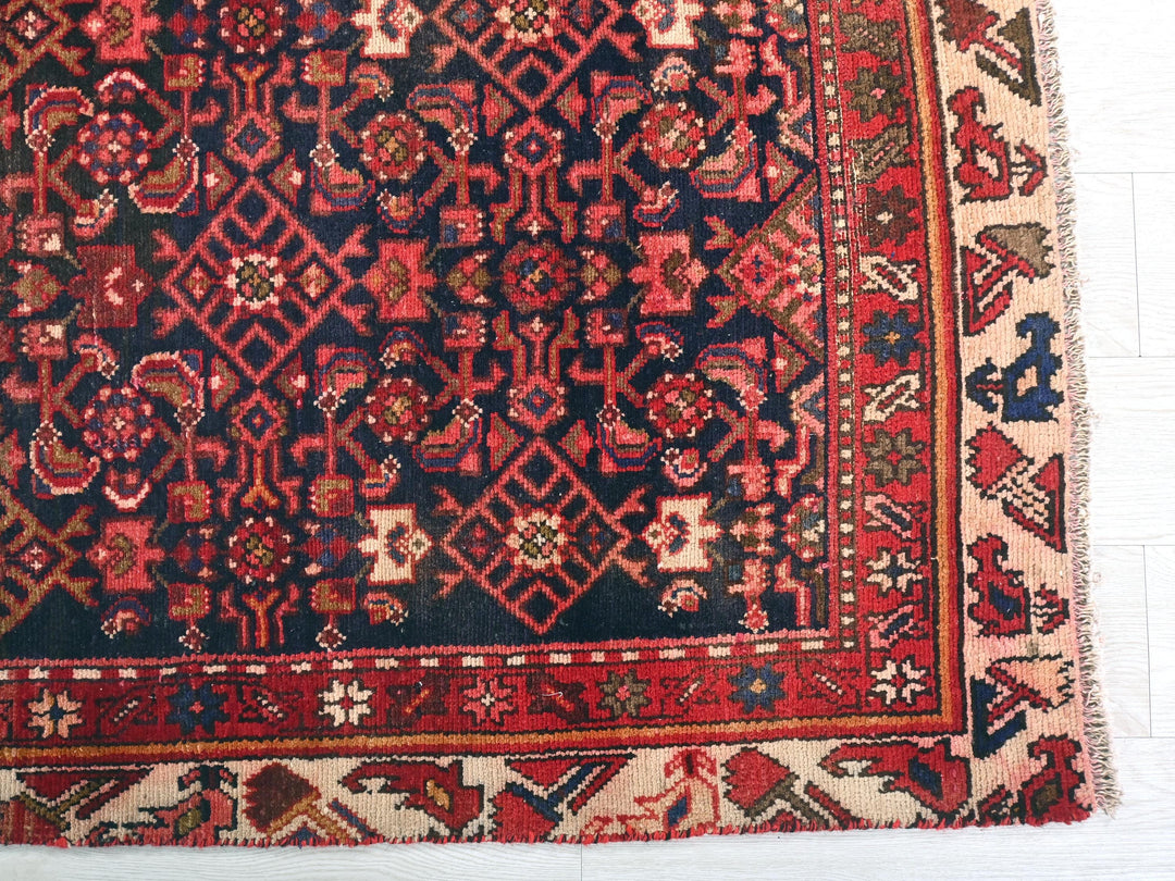 a red and black oriental rug on a white floor