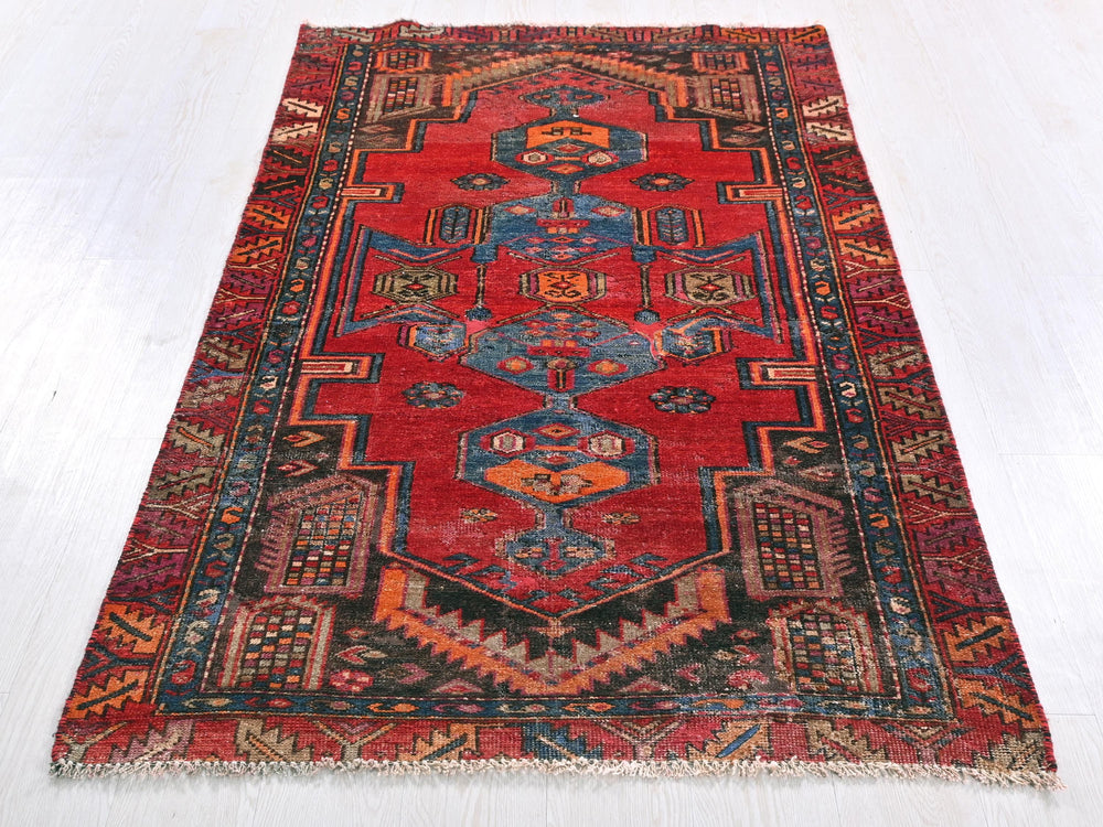 a red rug with a blue design on it