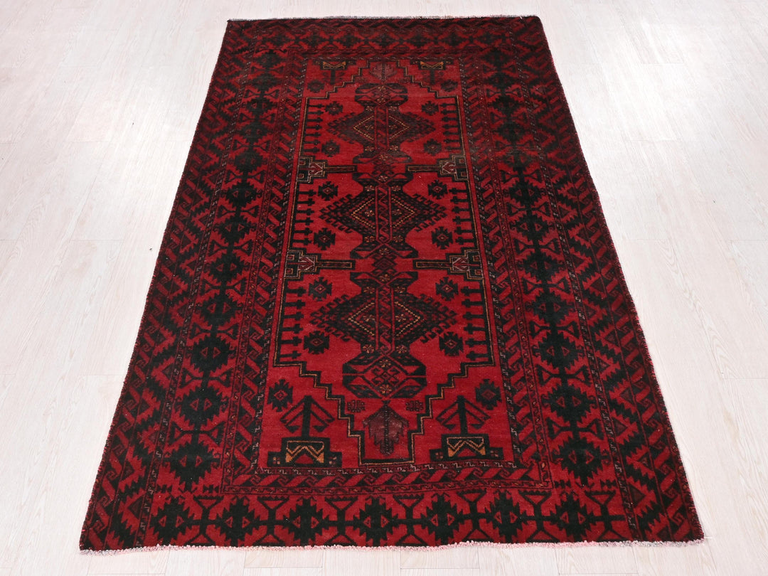 a red and black rug on a white floor