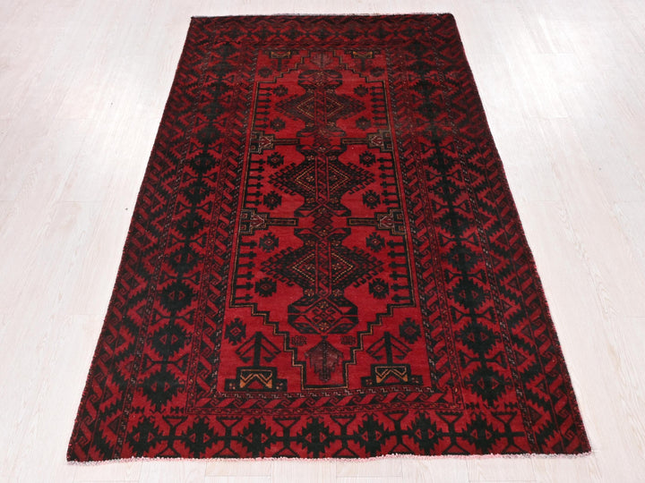 a red and black rug on a white floor