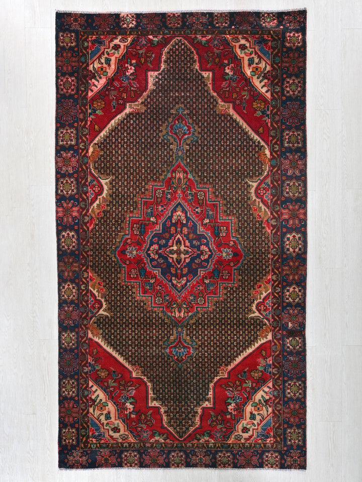 a red and blue rug hanging on a wall