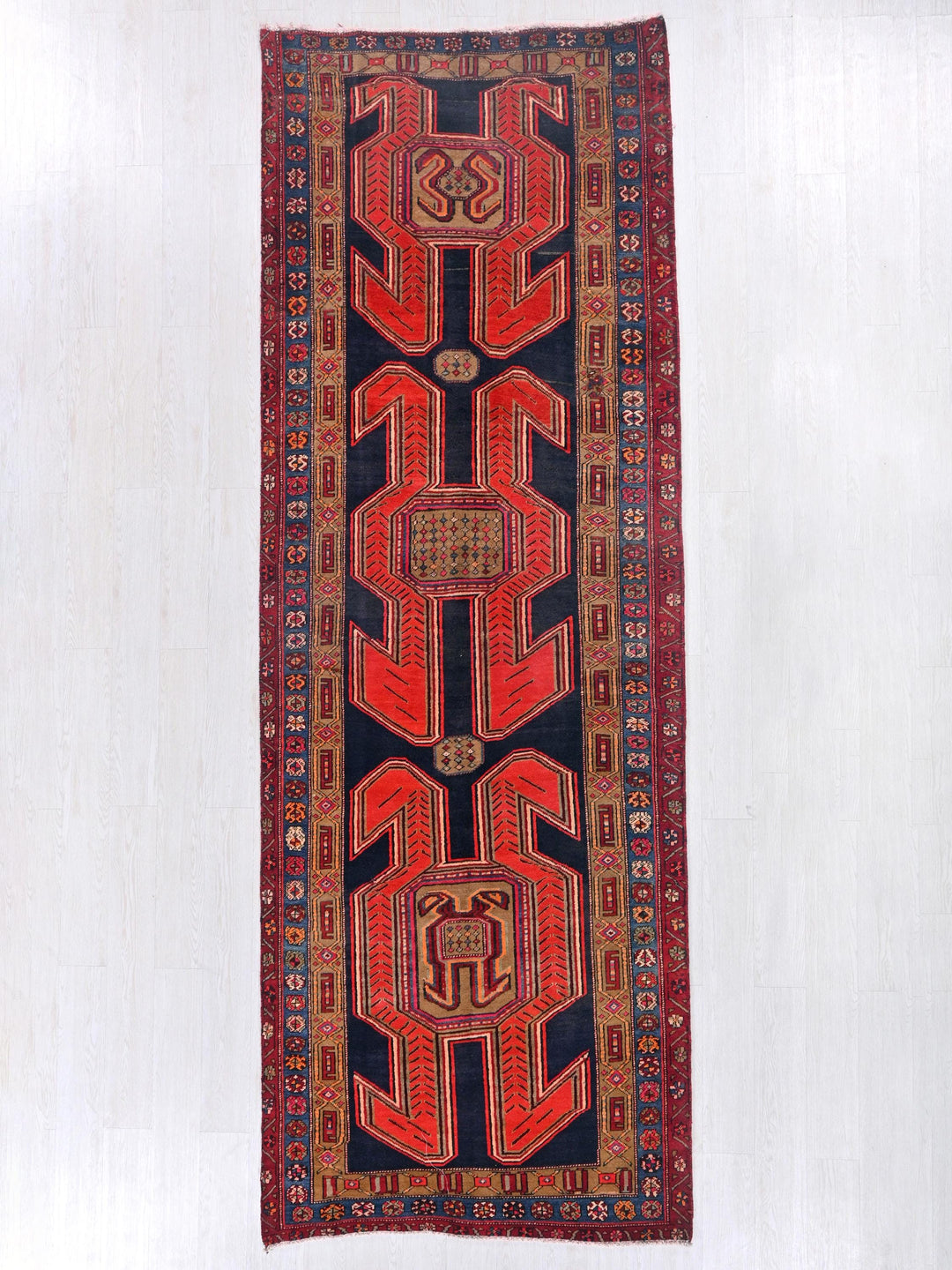 a red and black rug hanging on a wall