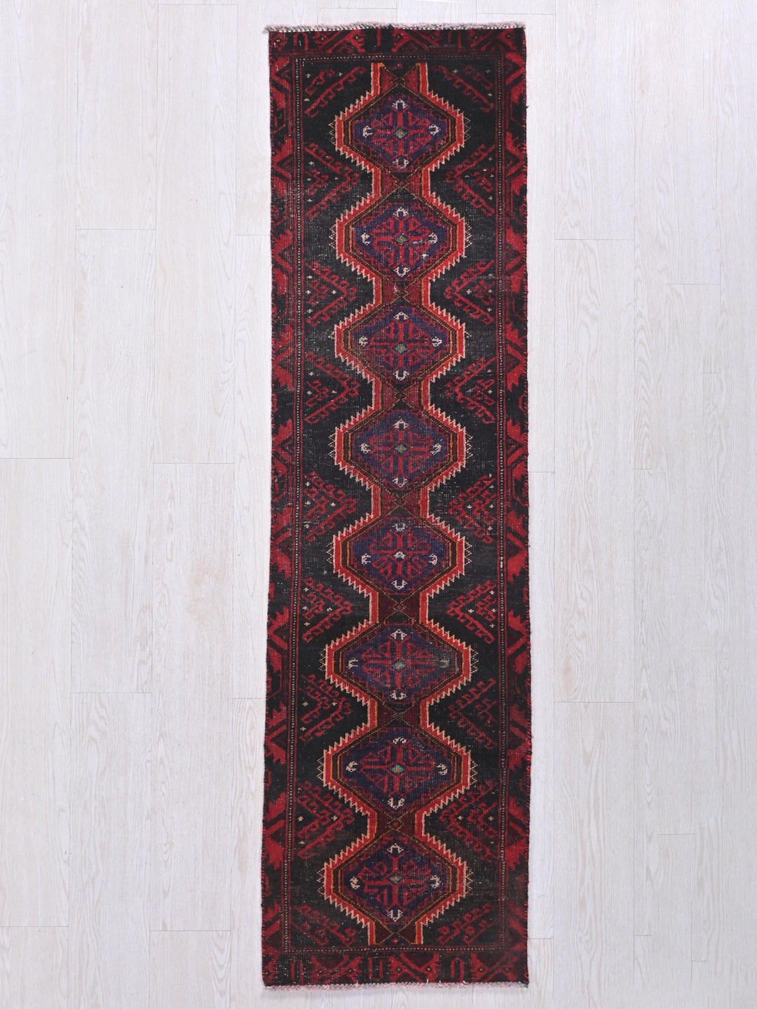 a red and black rug hanging on a wall