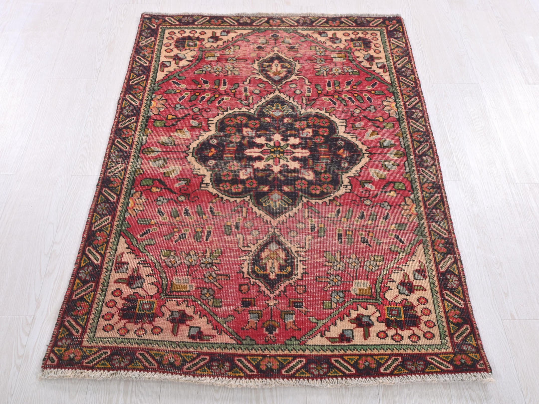 a red rug with a floral design on a white floor