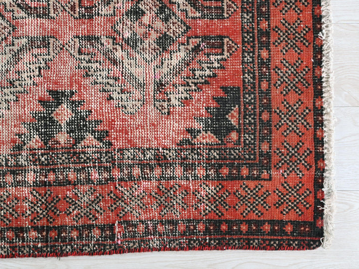 a red rug with black and white designs on it