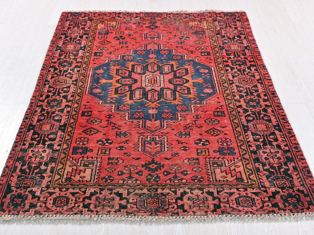 a red rug with a blue and orange design on it