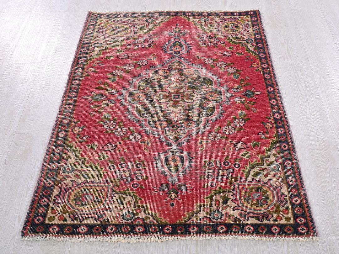 a red rug on a white wooden floor