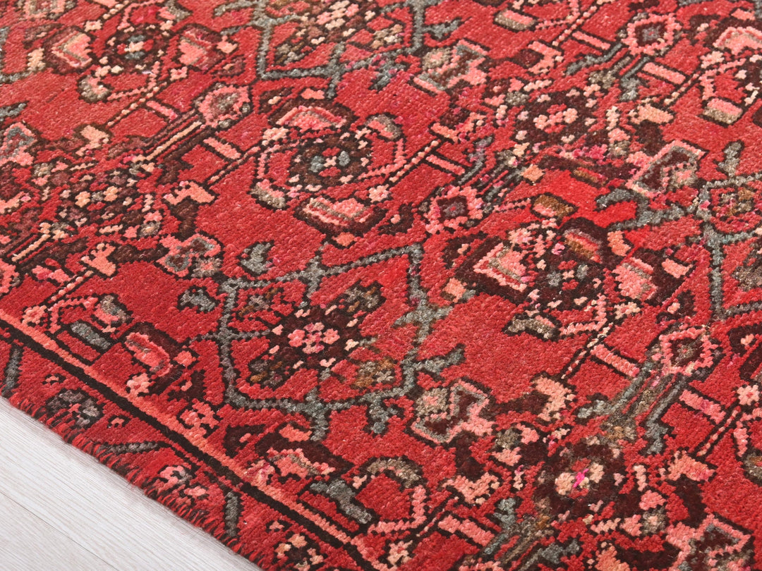 a close up of a red rug on a wooden floor