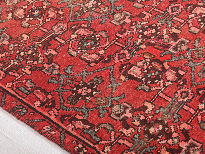 a close up of a red rug on a wooden floor