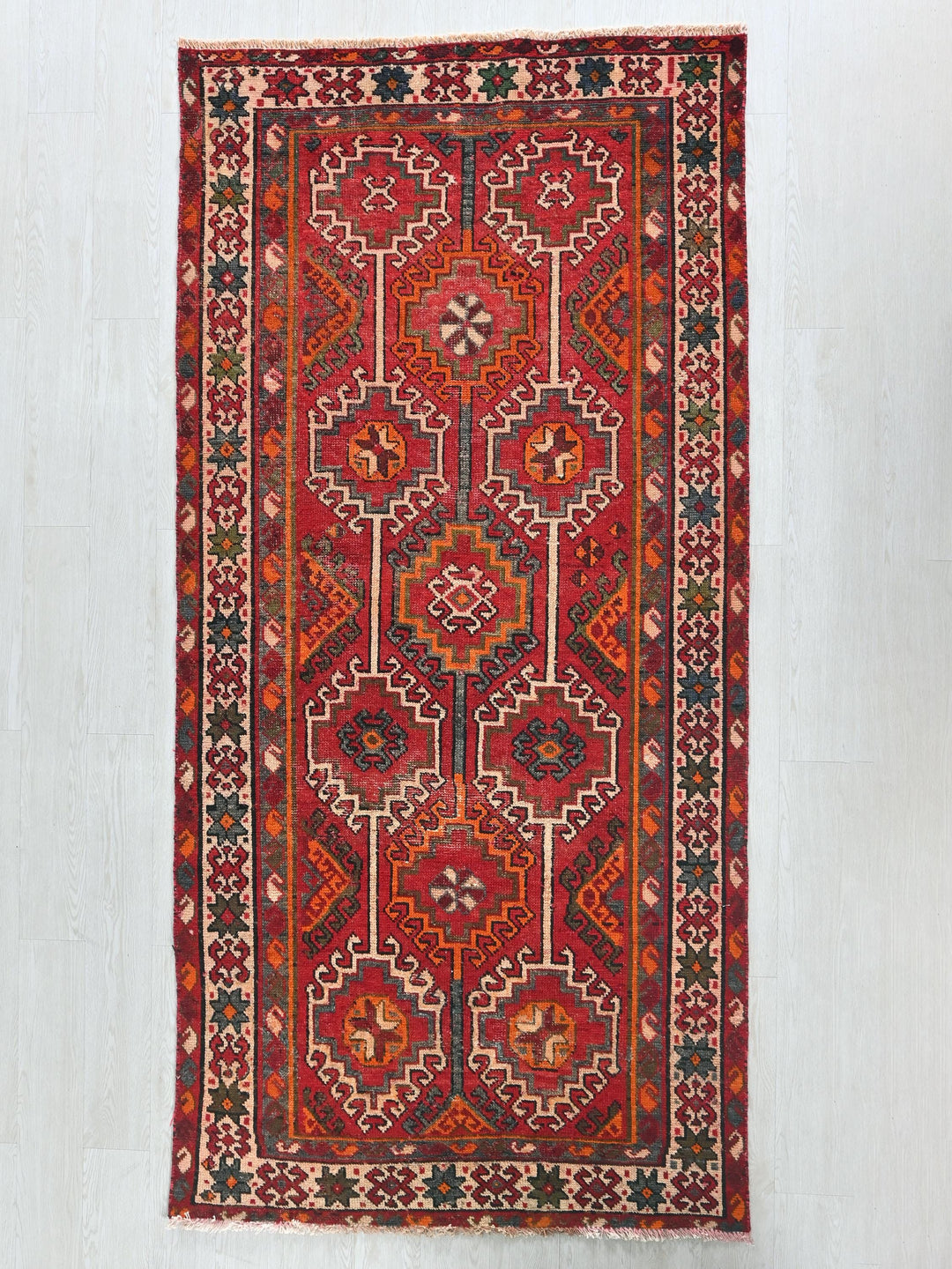 a red rug hanging on a wall