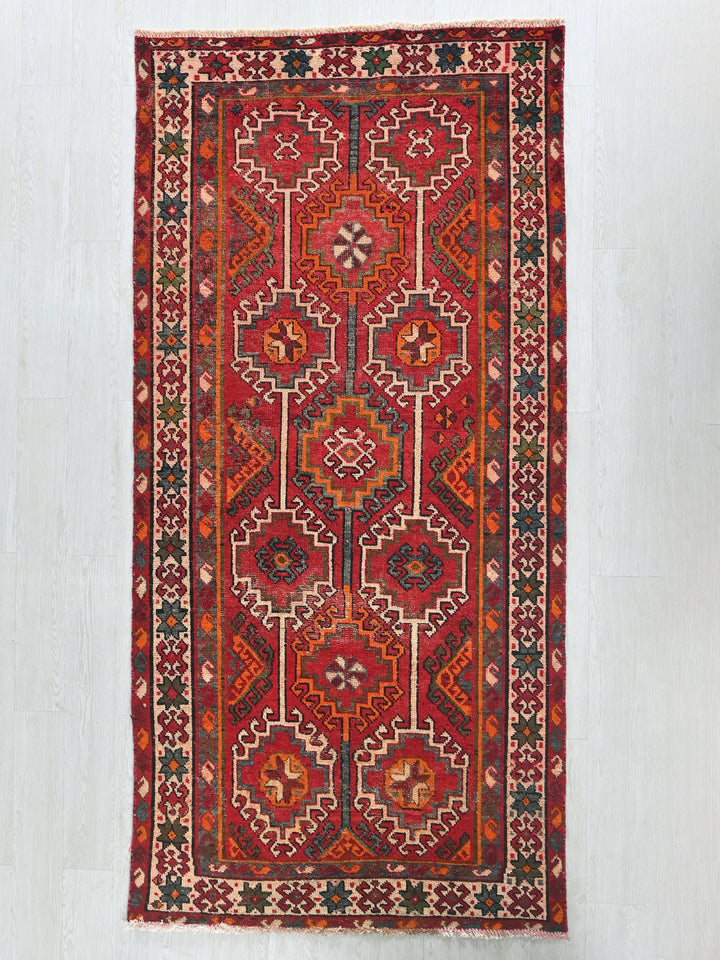 a red rug hanging on a wall