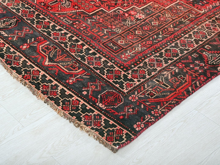 a red and black oriental rug on a white floor