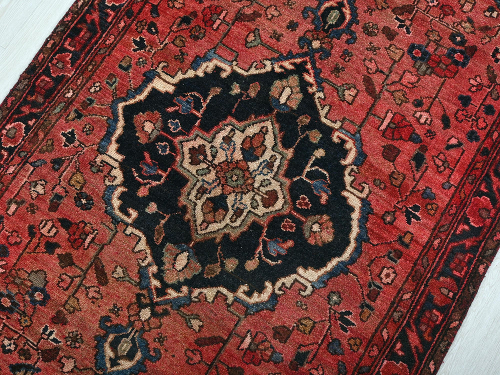 a red rug with a black and blue design on it