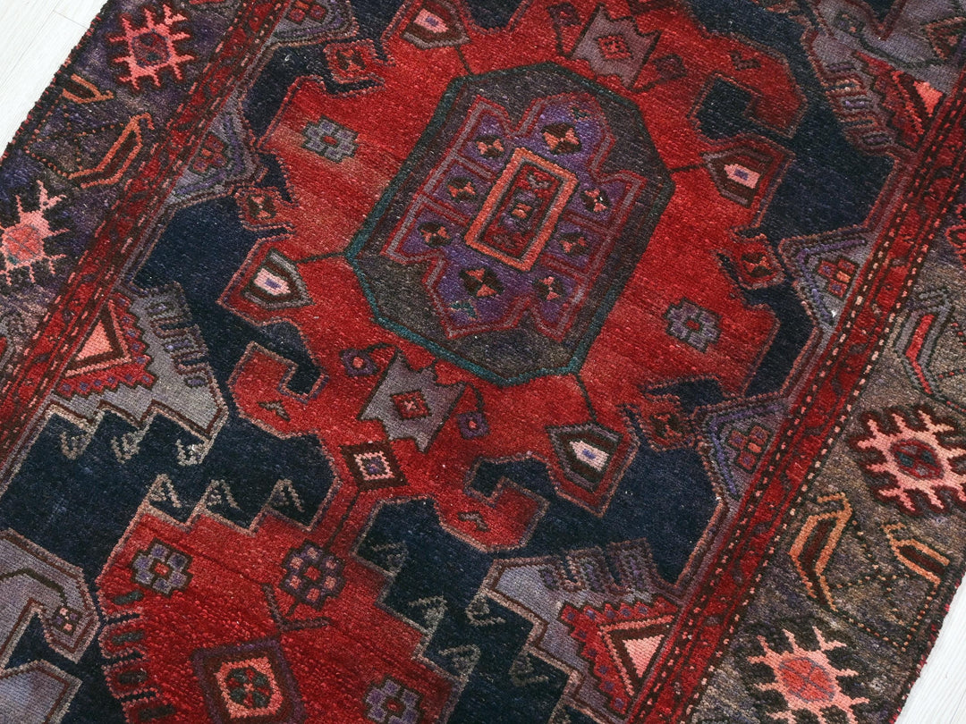 a red and black rug with a design on it
