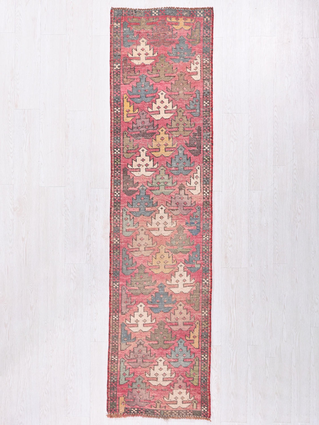 a red and blue rug hanging on a wall