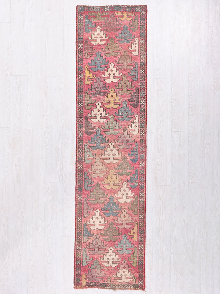 a red and blue rug hanging on a wall