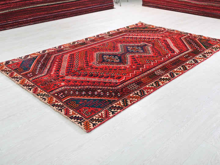 a red oriental rug on a white floor