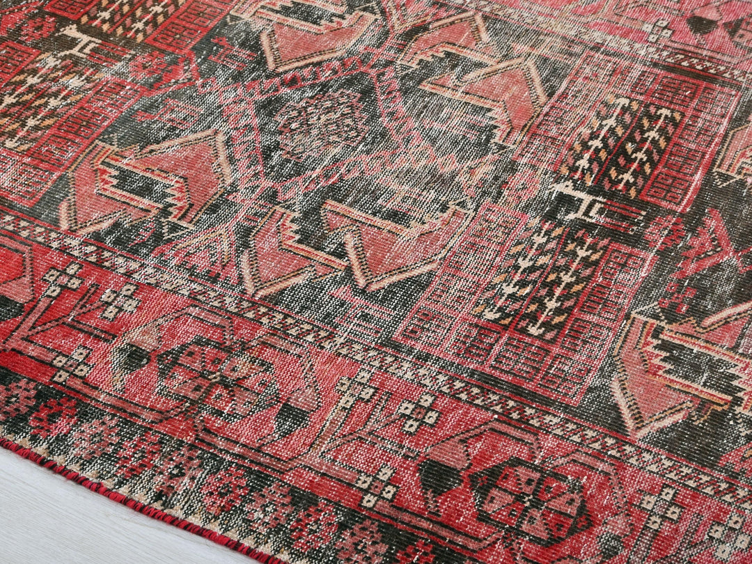 a red and black oriental rug on a white floor