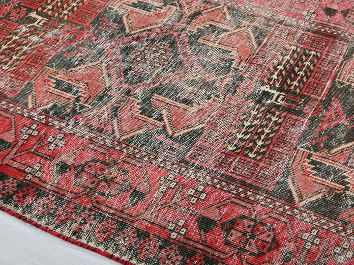 a red and black oriental rug on a white floor