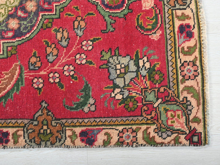 a red rug with a floral design on it