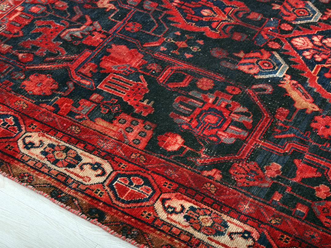 a red and black oriental rug on a white surface
