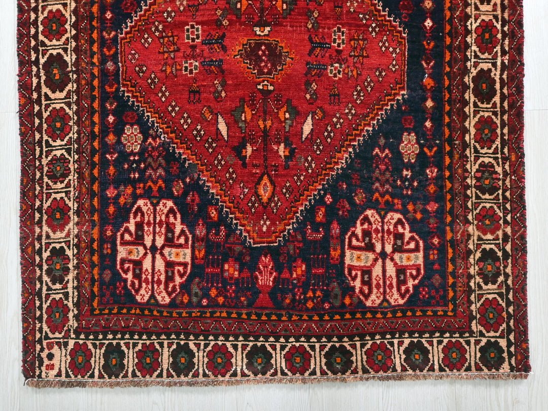 a red and blue rug with an intricate design