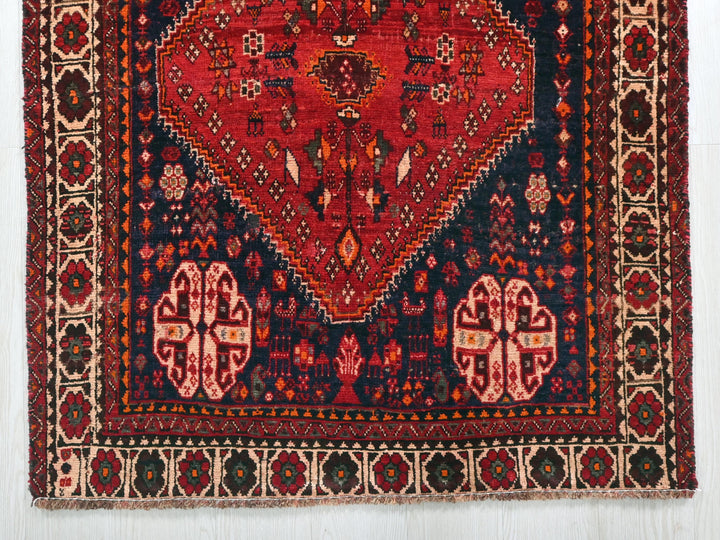 a red and blue rug with an intricate design