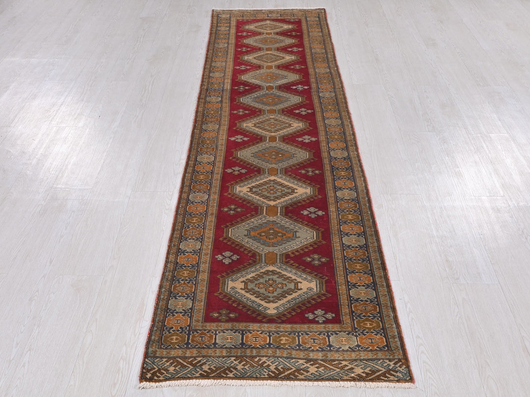 a long red runner rug on a white floor