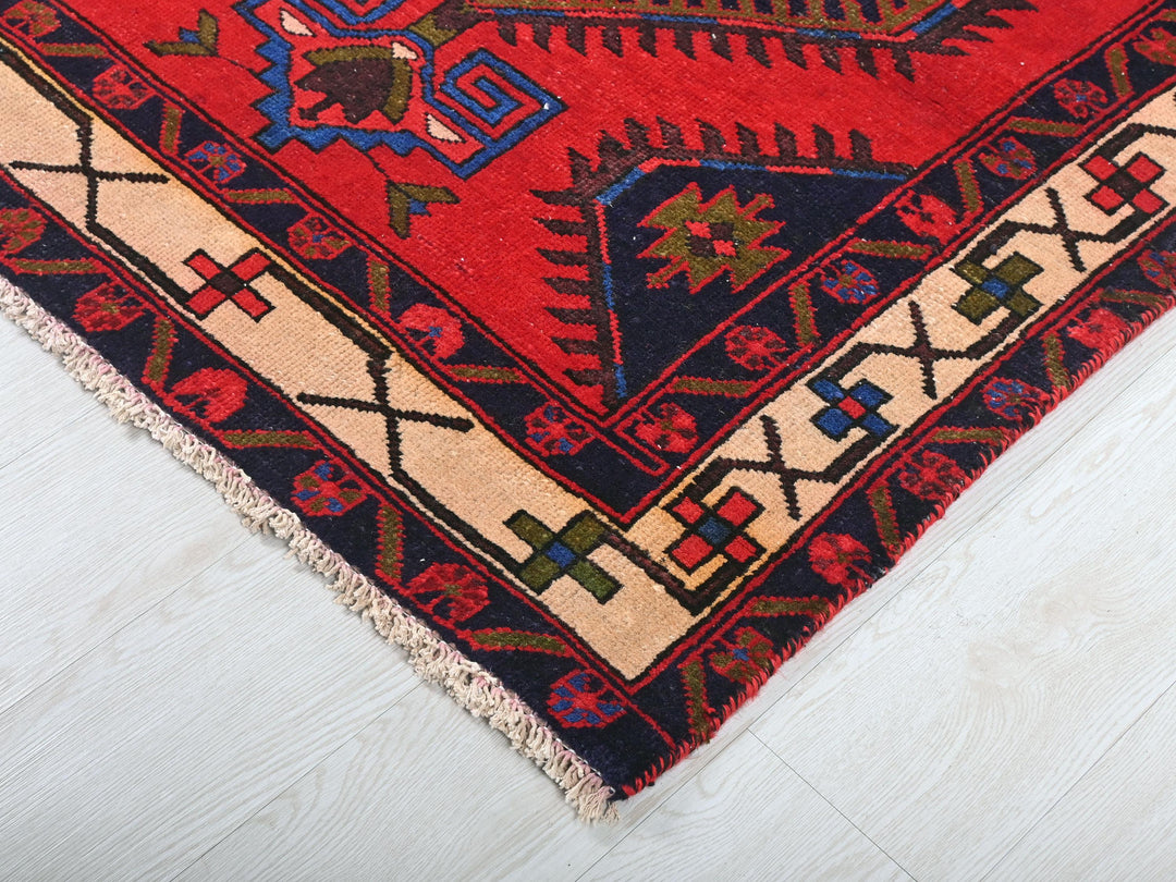 a red and blue oriental rug on a white floor