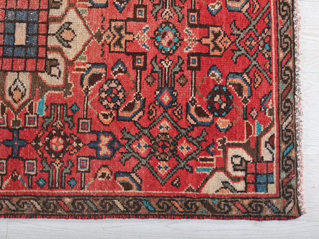 a red rug with a pattern on it