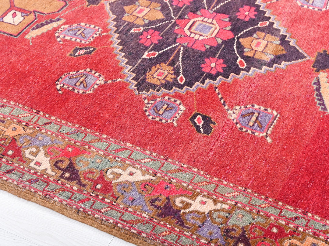 a close up of a red rug on a white floor