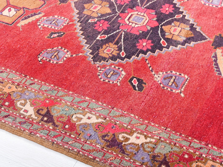 a close up of a red rug on a white floor