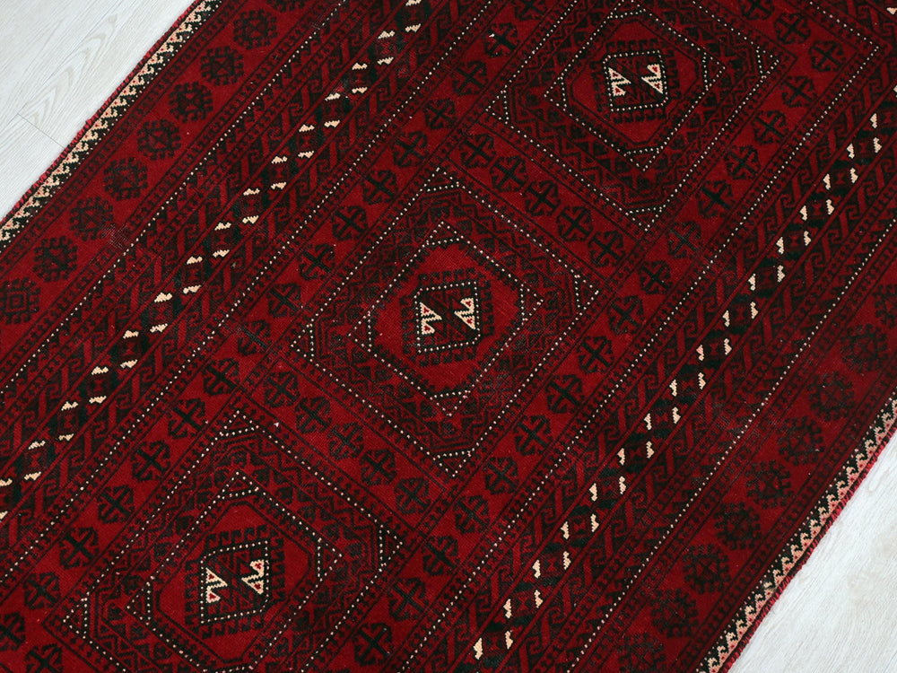 a close up of a red rug on a wooden floor