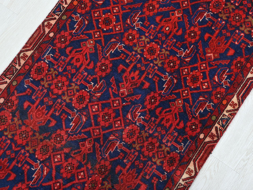 a red and blue rug on a white floor