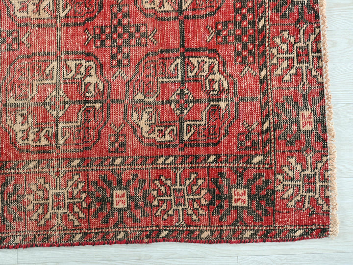 a red and black rug on a white surface