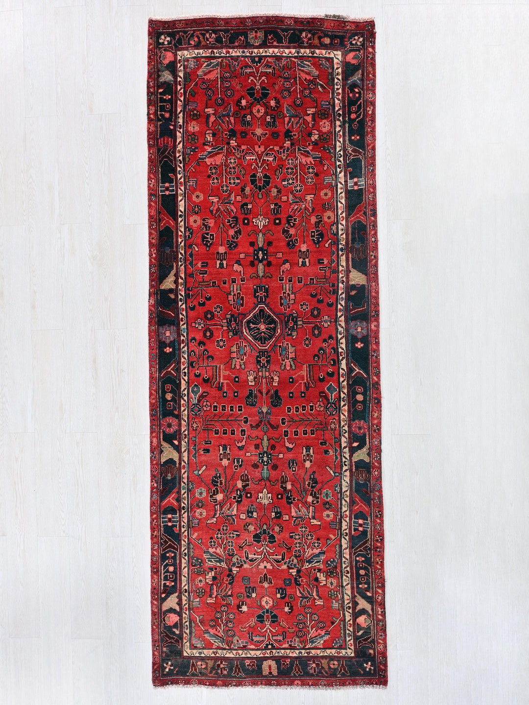 a red rug hanging on a white wall