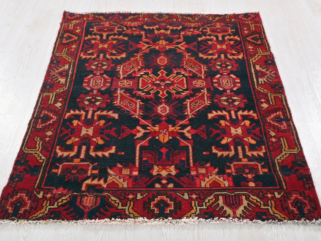 a red and black rug on a white floor