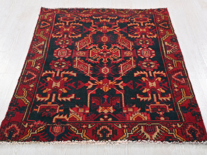 a red and black rug on a white floor