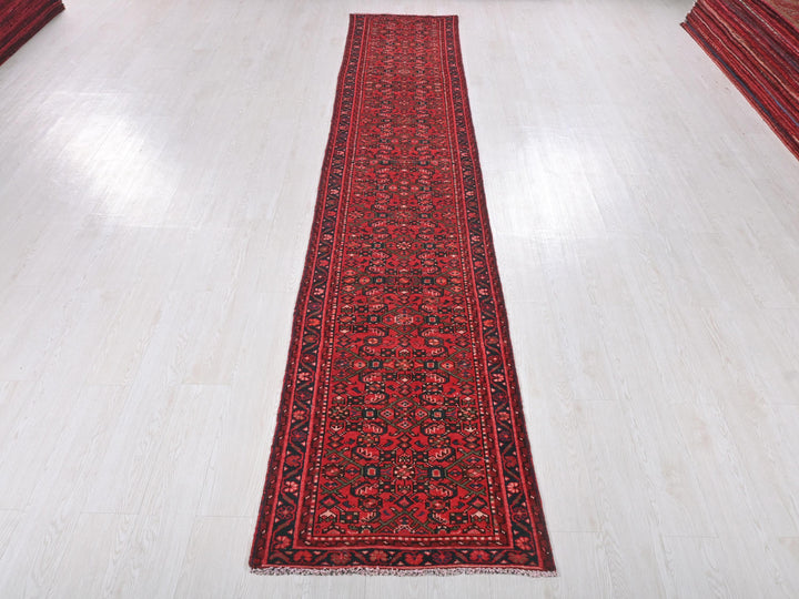 a long red rug on a white floor